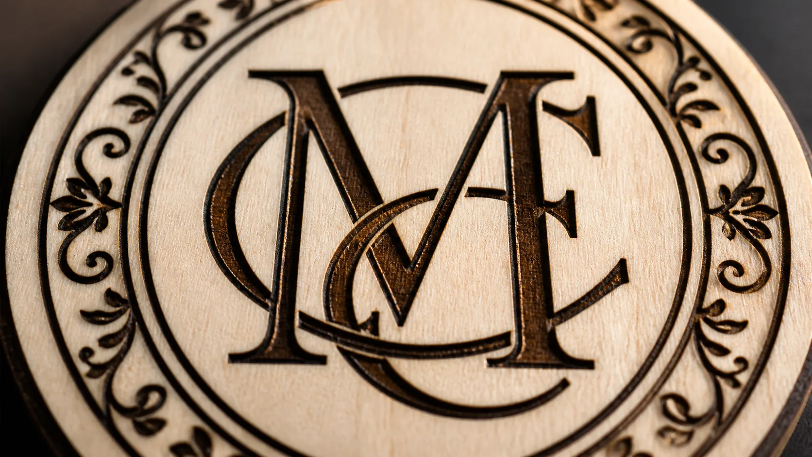 Close-up of laser-engraved monogram on 3mm basswood coaster—sharp detail and clean edges