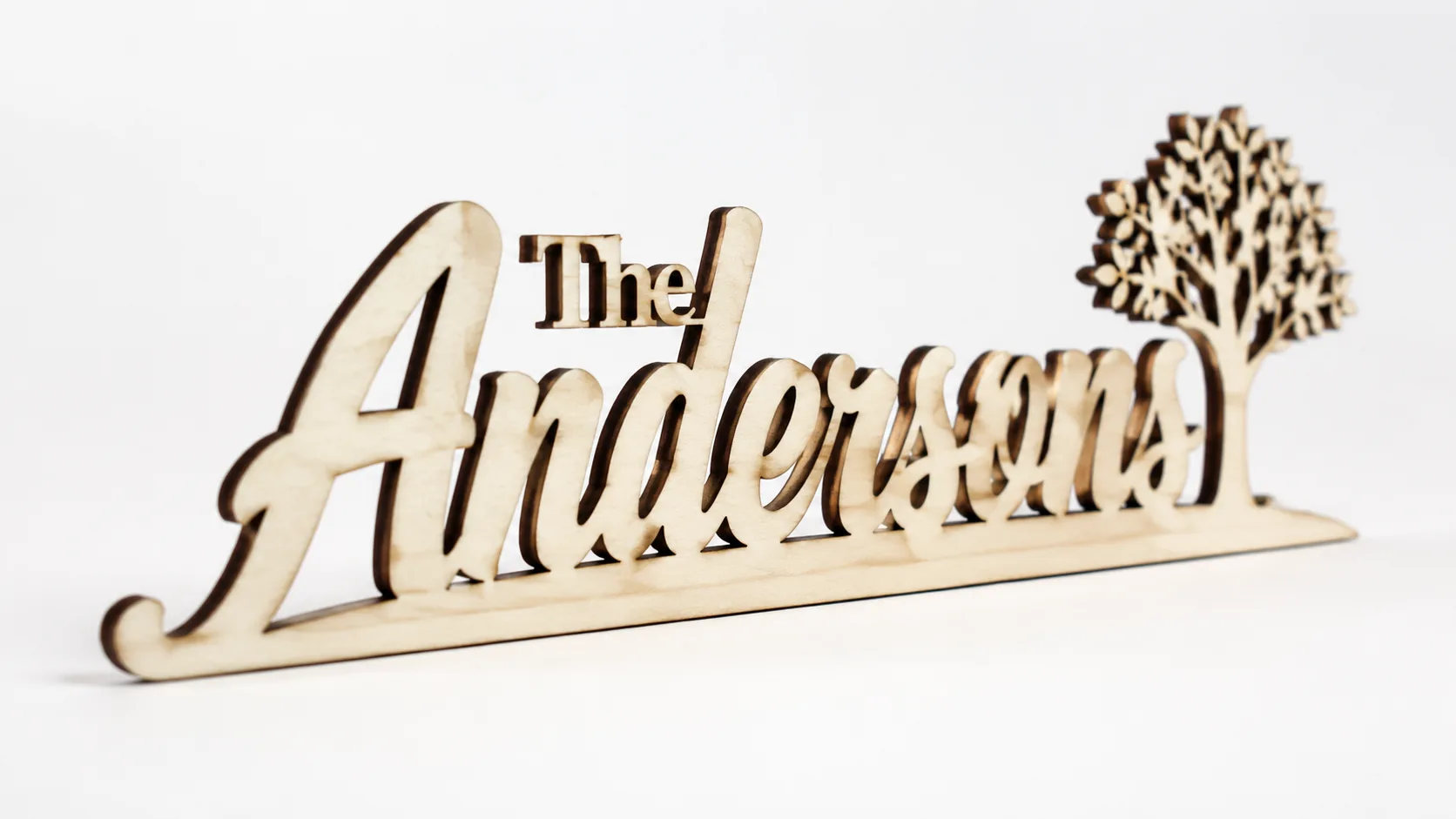 Laser-cut family name sign made from 3mm basswood, displayed on workshop table