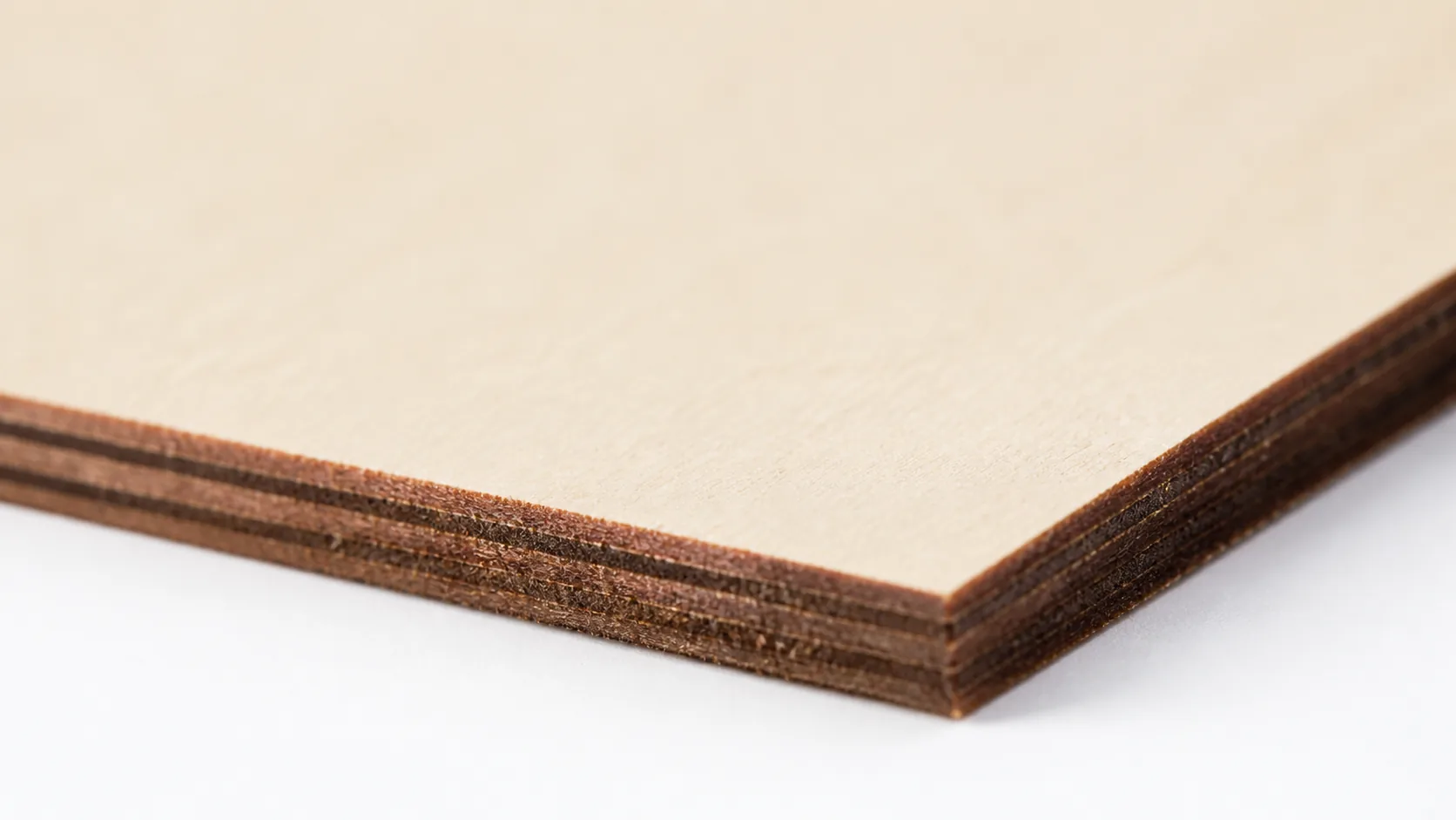 Close-up of 3mm basswood sheet edge showing pale cream surface and laser-cut detail