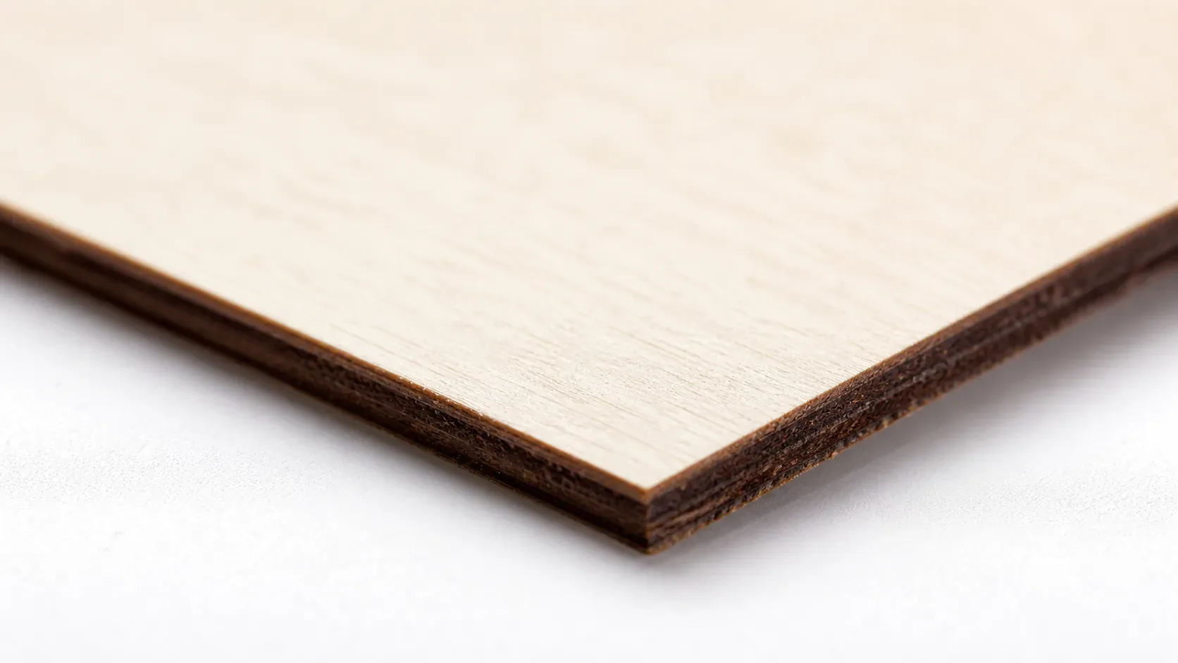 Close-up of 3mm basswood sheet edge showing pale cream surface and laser-cut detail