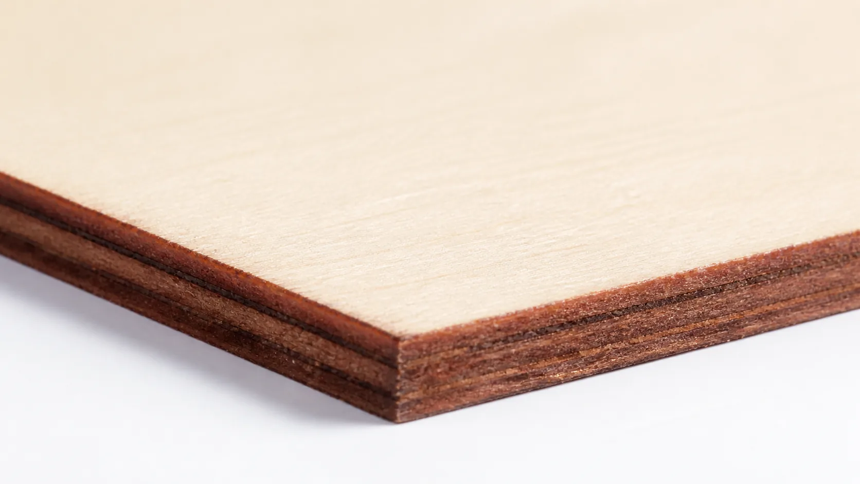 Close-up of 3mm basswood sheet edge showing pale cream surface and laser-cut detail with warm brown edge
