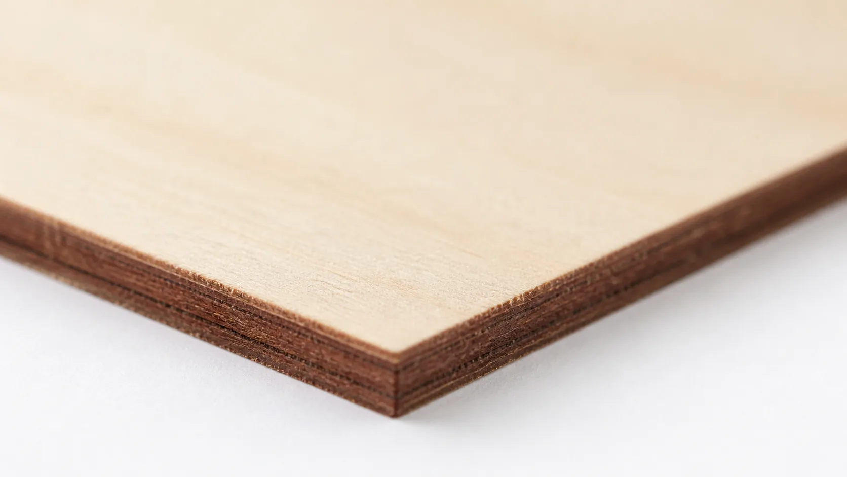 Close-up of 3mm basswood sheet edge showing pale cream surface and laser-cut detail